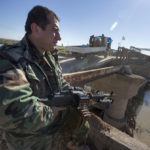 Ein Peschmerga bewaffnet mit einem russischen Maschinengewehr auf seinem Posten an der strategisch wichtigen Behelfsbrücke vor der Stadt Mosul.